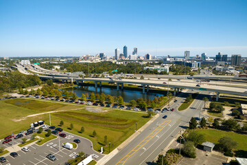 Aerial view of Jacksonville city with high office buildings and american freeway intersection with fast driving cars and trucks. View from above of USA transportation infrastructure