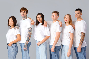 Group of young people in white t-shirts on light background