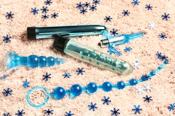 Sex toys with Christmas decor on beige fluffy carpet
