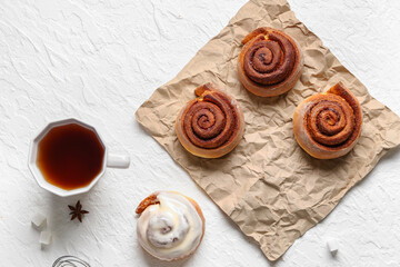 Fototapeta na wymiar Tasty cinnamon rolls and cup of tea on white background