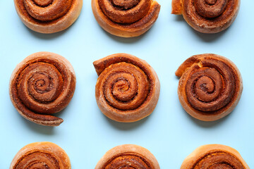 Tasty cinnamon rolls on blue background