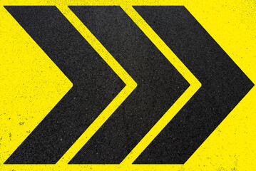 Chevrons noirs sur asphalte peint en jaune