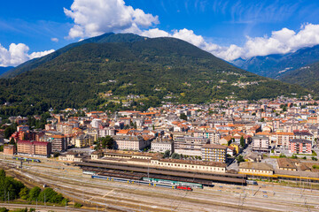 Fototapeta na wymiar Summer view from drone of small town of Domodossola in Ossola valley surrounded by green Alps overlooking railway, Italy .