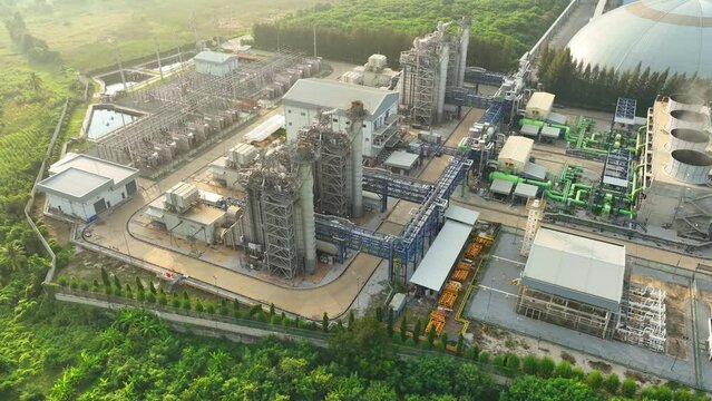 Aerial view of the power plant amidst serene nature showcases the striking contrast between human engineering and the tranquil beauty of the natural world, a reminder of our impact on the environment.