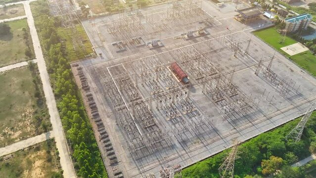These substations manage electricity flow, reducing voltage for safe consumption in homes and industries, enhancing grid stability, and preventing power outages. Bird's eye view by drone.

