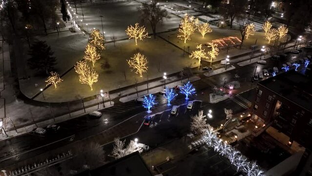 City park decorated with Christmas lights - pullback aerial