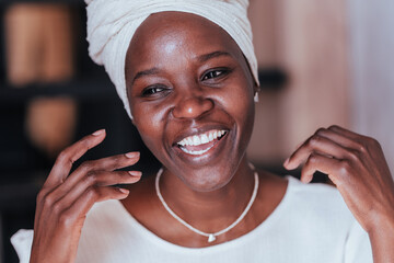 Close up picture of cheerful young African girl in white turban toothy smiles happy by great news....