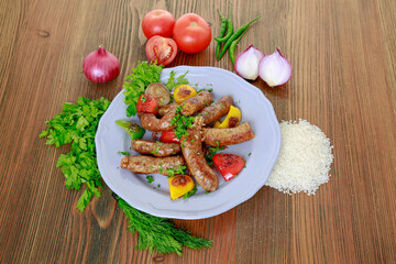 Grilled mumbar or sausage grill with onion, tomato and coriander served in dish isolated on table top view of arabic food