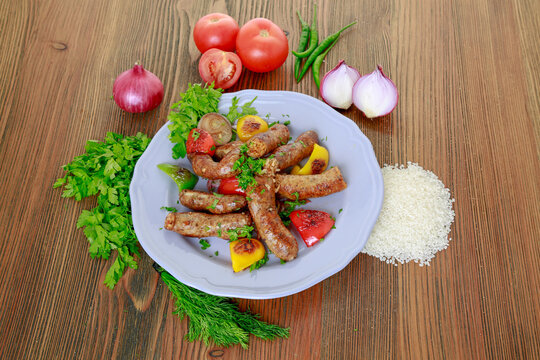 Grilled mumbar or sausage grill with onion, tomato and coriander served in dish isolated on table top view of arabic food