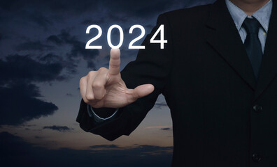 Businessman pressing 2024 letter over sunset sky, Business happy new year 2024 cover concept