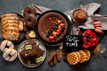 Tasty cake, cookies, waffles, macaroons, muffin. Delicious desserts on dark background. Food concept