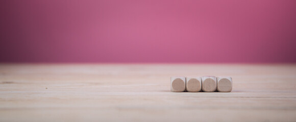 Square wooden blocks on pink background.