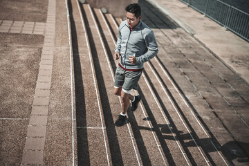 A man  running up on stairs in the city center park for cardio workout.  Health and Lifestyle in big city life concept.