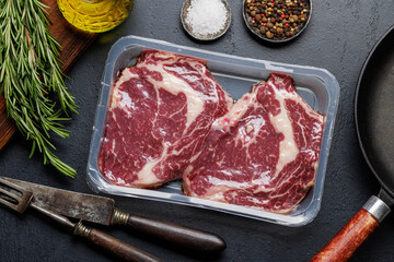 Raw ribeye steaks with savory spices