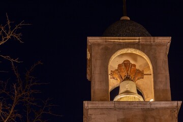 Illuminated Tower Bell on Old Catholic Church Exterior, Night Sky Background.  Tlaquepaque Spanish Arts and Crafts Village Sedona Arizona Southwest US