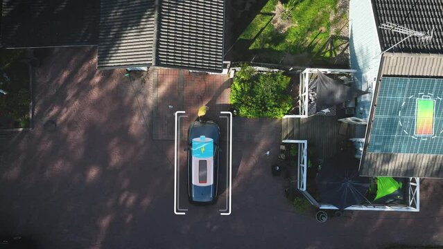 Man charging a electric car on a house yard with electricity from solar panels