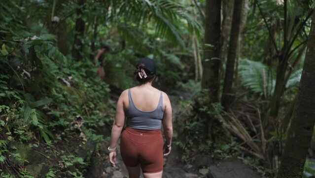 Slow motion shot of a woman hiking through the dense Puerto Rican jungle