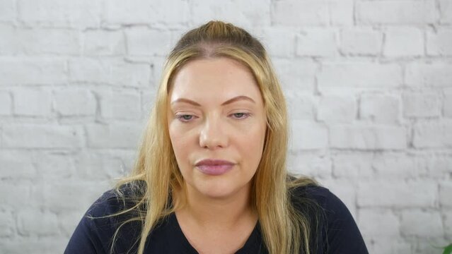 An unimpressed bored and skeptical blonde woman looking sarcastic and disgusted