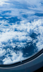 Sky blue background with white clouds, showcasing the beauty of nature. View from airplane window