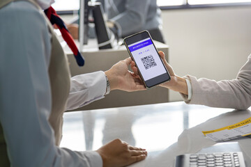 Passenger is showing online check in qr code boarding pass to the airline ground crew at departure gate counter into the airplane for final inspection before boarding into the  plane