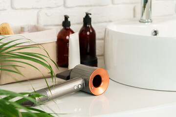 Electric hair dryer on counter in the bathroom.