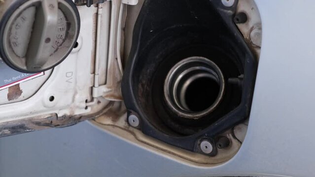 Fuel nozzle being taken out after filling the fuel tank of a truck, gas station in Thailand.