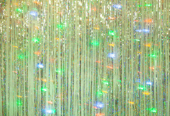 New Year party background of green tinsel and colored garland....
