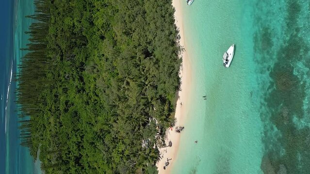 Motorboats bring tourists to ilot Moro to fish and grill their catch on the picturesque beach - descending vertical aerial tilt up