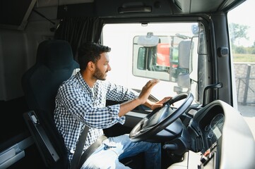Happy professional truck driver driving his truck. Copy space.