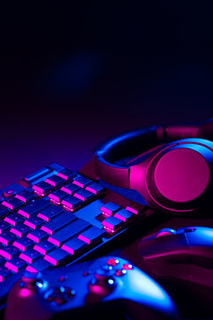 Headphones, joystick and computer keyboard on black table