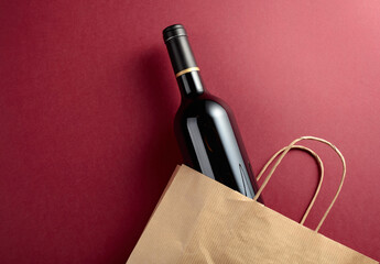 Paper shopping bag with a bottle of red wine.