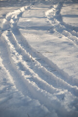 Fototapeta na wymiar snowmobile tracks on white snow