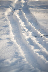 Fototapeta na wymiar snowmobile tracks on white snow