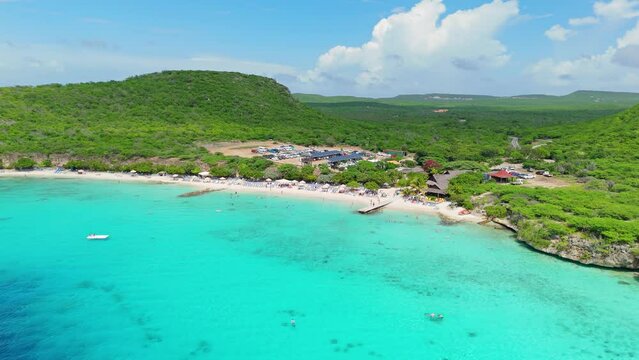 Wide angle aerial orbit rises above Playa Porto Mari on sunny day in Curacao