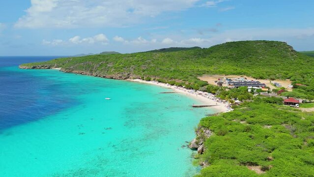 Panoramic aerial dolly above Playa Porto Mari, gradient dark blue to turquoise green crystal clear Caribbean water