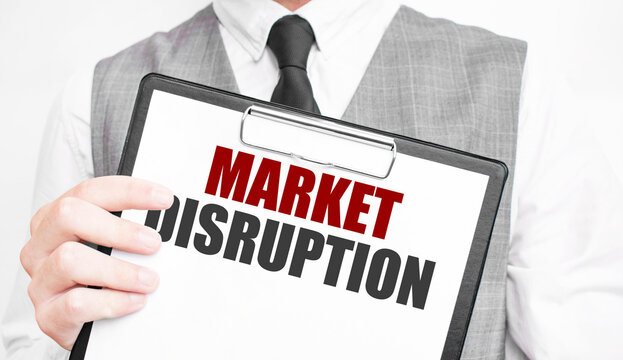 MARKET DISRUPTION inscription on a notebook in the hands of a businessman