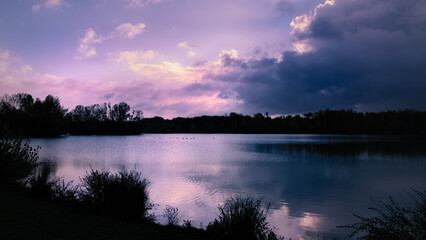 Fototapeta premium Lever de soleil sur le lac du parc de la Lère à Caussade avec de magnifiques couleurs mauves