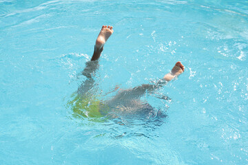 Youthful legs kick, submerged in water; a moment of pure leisure, reflecting universal aquatic fun.