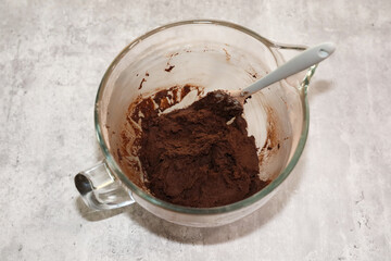 Chocolate sugar cookie dough in a mixer glass bowl ready to be rolled out.