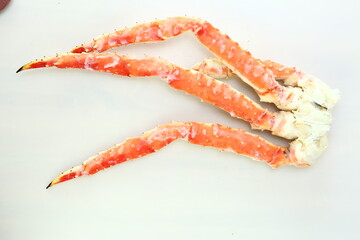 frosted Alaska king crab legs close up photo on white table background