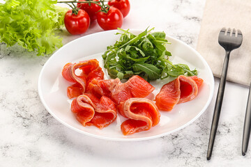 Sliced salmon with fresh arugula