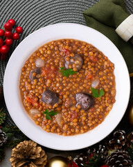 Lentils with chorizo ​​and black blood sausage. Christmas food served on a table decorated with...