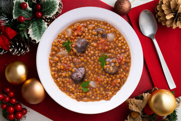 Lentils with chorizo ​​and black blood sausage. Christmas food served on a table decorated with...