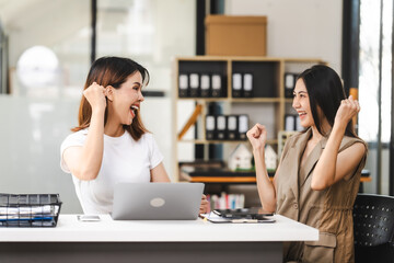 Two Asian colleagues, freelance writer and graphic designer discussing about creating characters in screenplays work and smiling with tablets and laptop, journalist, artist, cheerful, congratulation