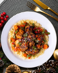 Moroccan-style marinated chicken with couscous. Food served on a table with Christmas decorations.