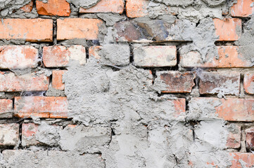 The background of the wall is made of brown bricks, laid out from a cement sand mortar