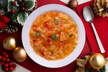 Menorcan soup with bread, peppers and white cabbage. Christmas food served on a table decorated with christmas motivs.