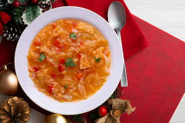 Menorcan soup with bread, peppers and white cabbage. Christmas food served on a table decorated with christmas motivs.