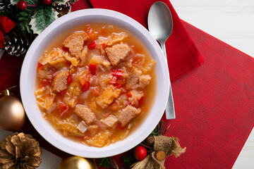 Menorcan soup with bread, peppers and white cabbage. Christmas food served on a table decorated with christmas motivs.