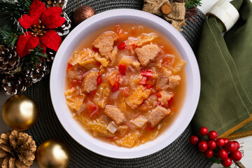 Menorcan soup with bread, peppers and white cabbage. Christmas food served on a table decorated with christmas motivs.